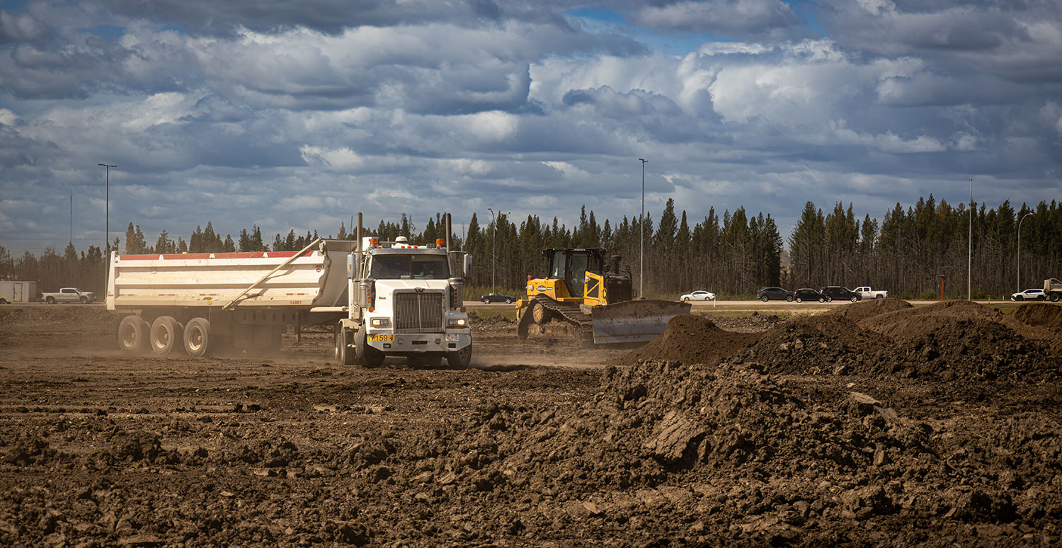 Hi-Tower truck and dozer moving soil during reclamation work at the Poundmaker peat fire site in west Edmonton, August 2025.